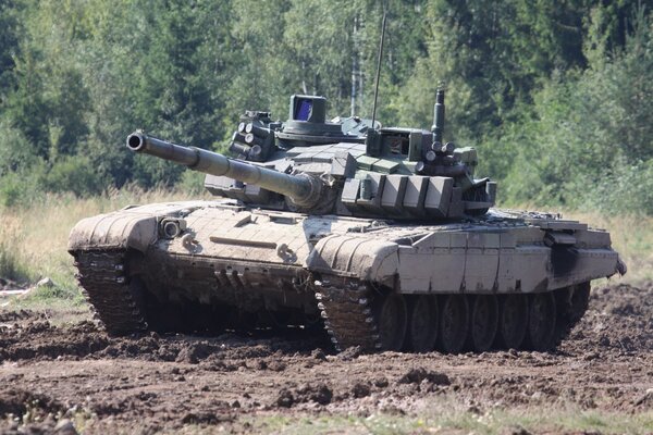 A battle tank rides through the mud