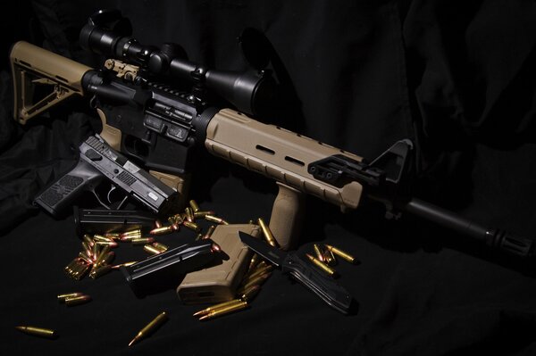 Assault rifle, pistol and knife on a black background
