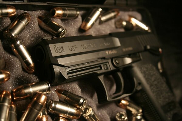 A pistol on a black background surrounded by cartridges