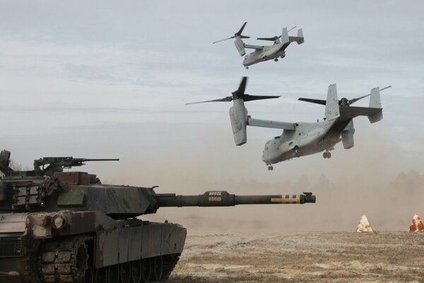 Photo of a battle tank on the background of tiltrotor planes