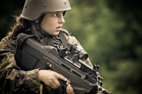 The girl in the helmet is armed with a machine gun