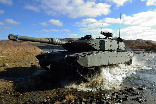 Leopard 2a6 battle tank, photo on the river with splashes and sky