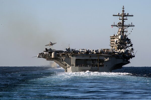 American McDonnell Douglas F/A-18 Hornet carrier-based fighter and the aircraft carrier USS George H. W. Bush in the Atlantic Ocean