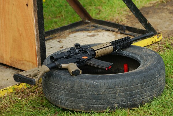 Assault rifle on a car tire