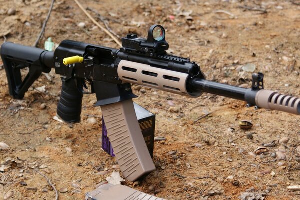 Automatic machine with a full magazine on a sandy background