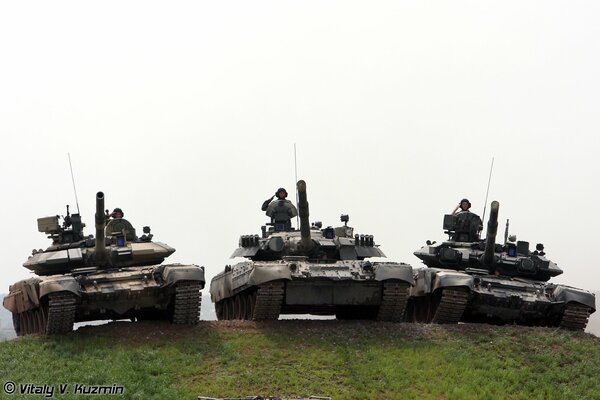 Three tanks lined up with tankers