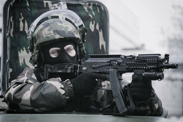 Żołnierz w kasku i masce z karabinem maszynowym