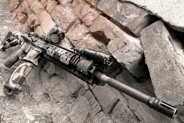 Photo gray machine gun with a sight brick wall