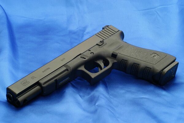 Schwarze Pistole Glock 17L auf blauem Hintergrund