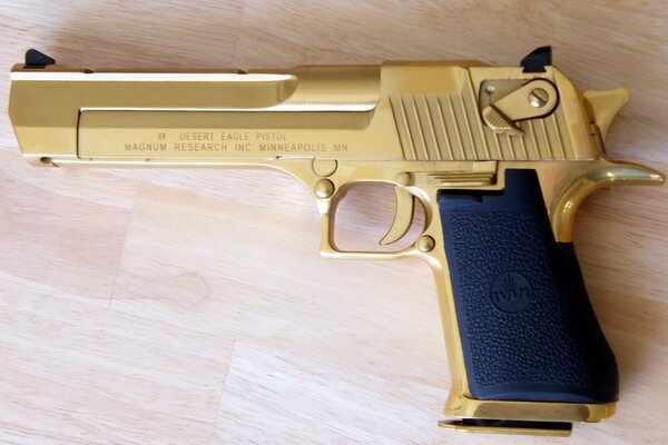 Золотой пистолет на фоне пола