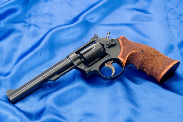 Smith & Wesson Revolver mit braunem Griff auf blauer Seide