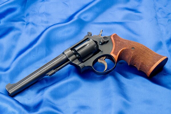 Smith & Wesson revolver with brown handle on blue silk