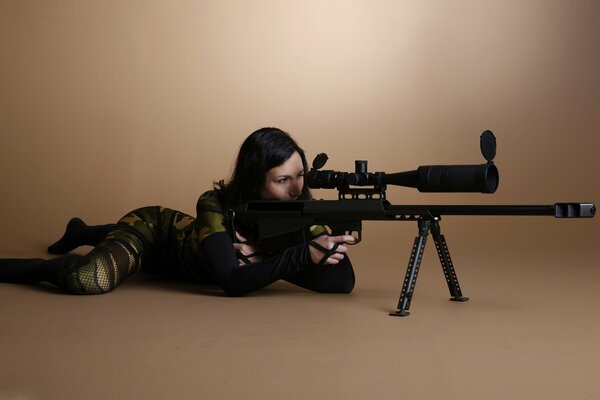 Imagen de una chica de francotirador en camuflaje con un arma