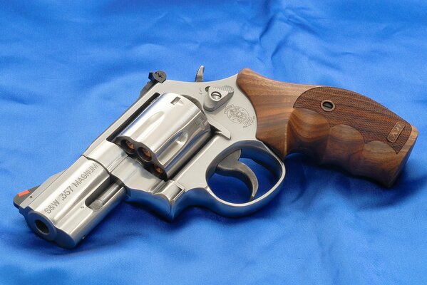 Revolver con decorazione in legno su raso blu