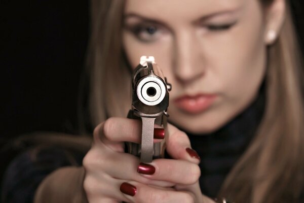 The girl is aiming a gun right at you