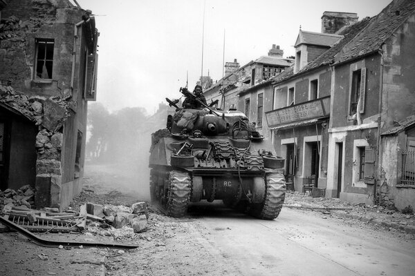 Un tanque rueda por la calle destruida entre las ruinas de las casas