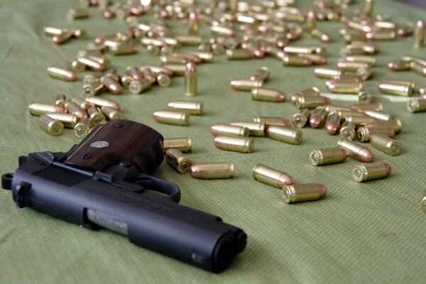 Pistol with cartridges on a green background