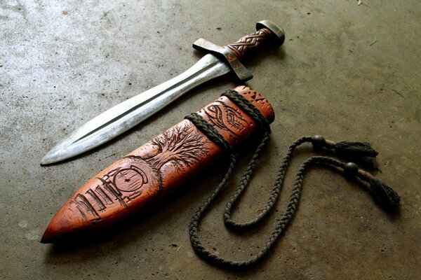 On the table there is a knife and a wooden case with a carving