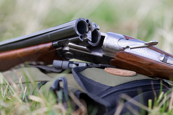 An unloaded pistol is lying on the grass