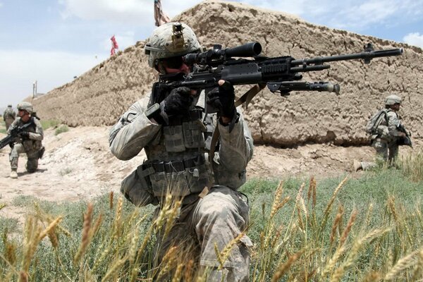 Soldado con armas de francotirador en el campo