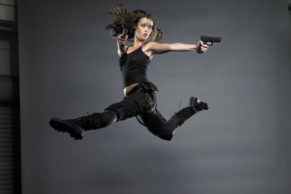 Chica en el salto con pistolas