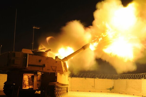 A flame comes out of the M109a2. There s barbed wire all around