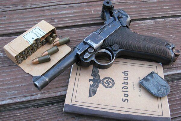 The theme of the Second World War. An old pistol with cartridges