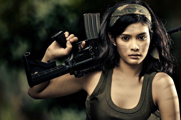 Brunette in khaki holds a machine gun