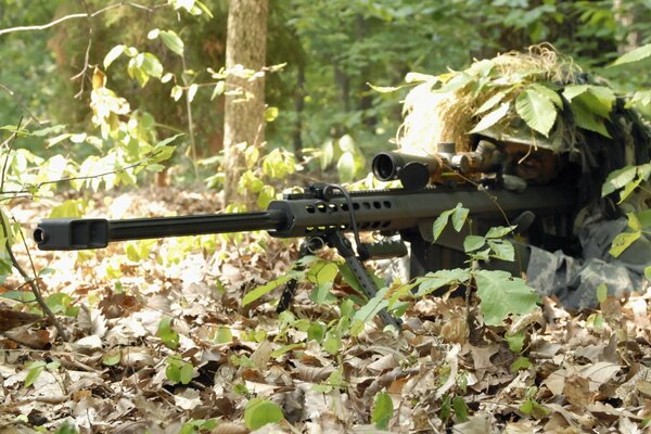 Sniper in a forest ambush with a rifle in his hands