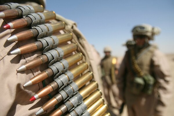 A soldier has a magazine with cartridges on his shoulder