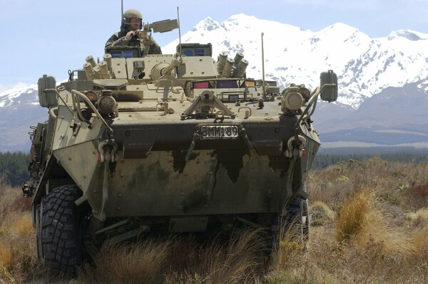 Soldiers on armored vehicles against the background of mountains