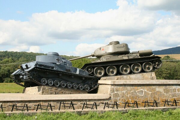 Gedenkstätte auf einem Steinsockel zwei Panzer im ungleichen Kampf