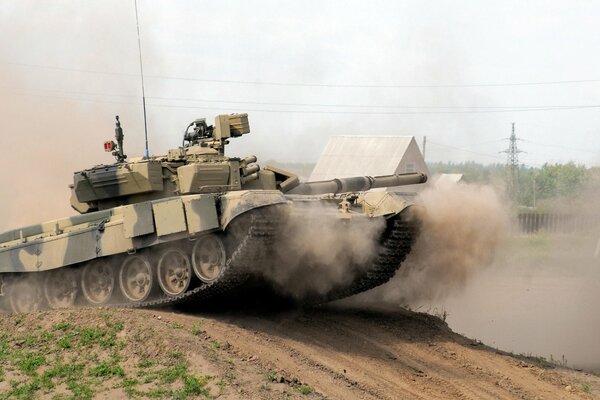 Tank T-90 fährt vor dem Hintergrund des Dorfes