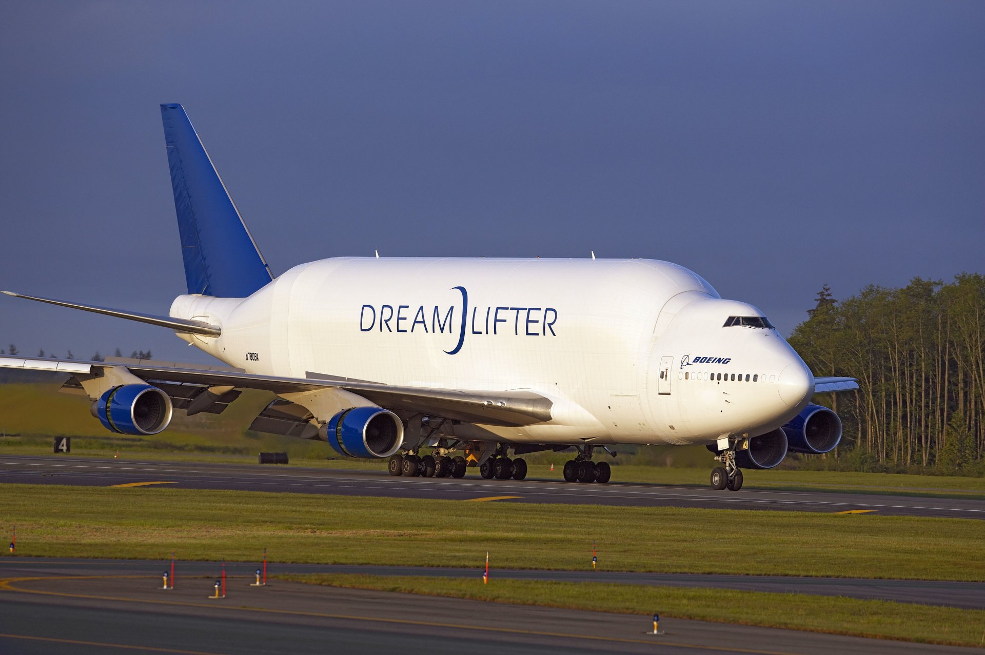 dreamlifter boeing airplane cargo airport landing runway runway wings engines landing gear trees sky airplane takeoff runway