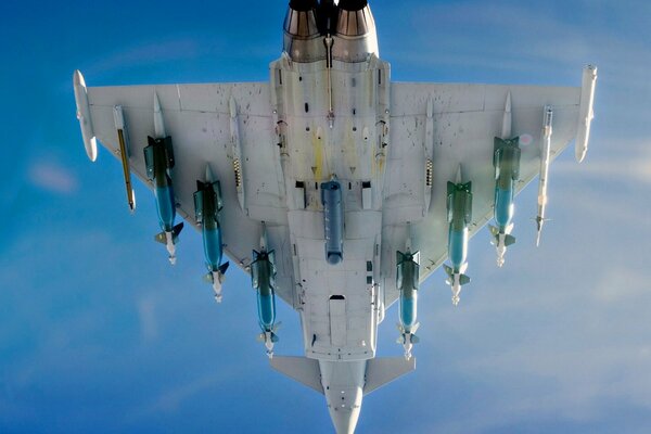 Military fighter with rockets in the sky