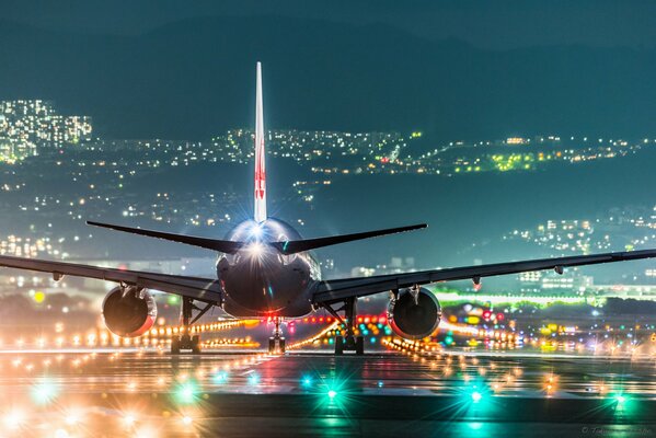 Aereo passeggeri nelle luci della città di notte