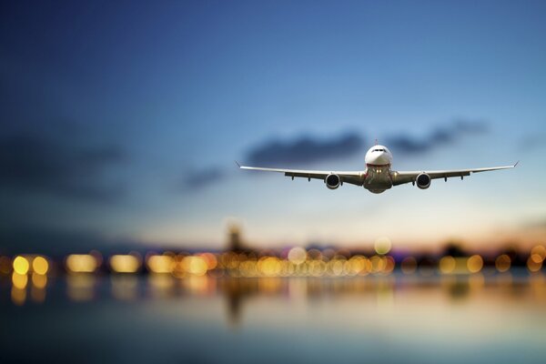 Passagierflugzeug am Himmel vor dem Hintergrund der Lichter der Stadt