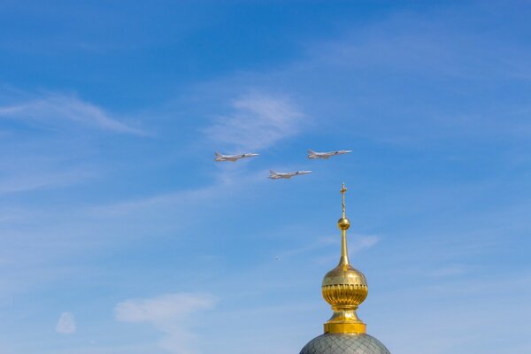 Три самолёта пролетают над куполом церкви