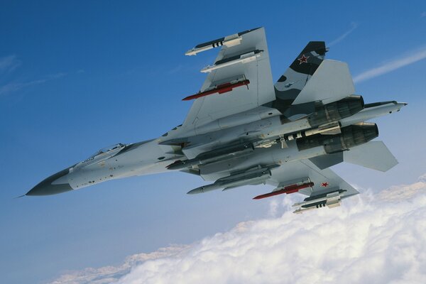 A military fighter is flying among the clouds