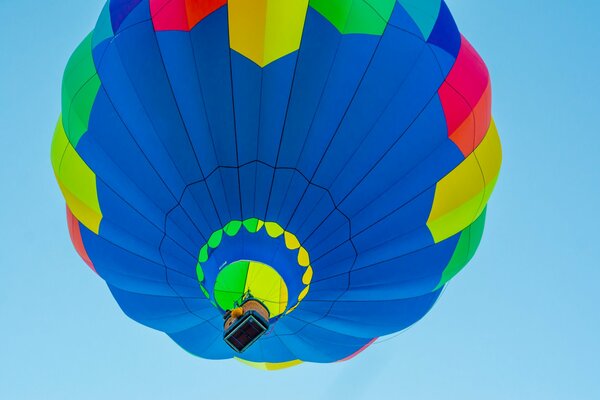 Volo del pallone con il canestro nel cielo blu