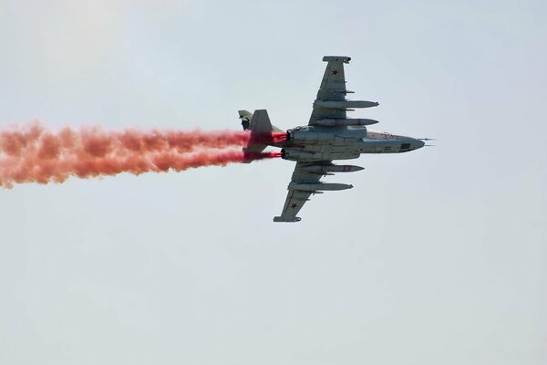 Samolot na niebie uwalnia kolorowy dym. Airshow