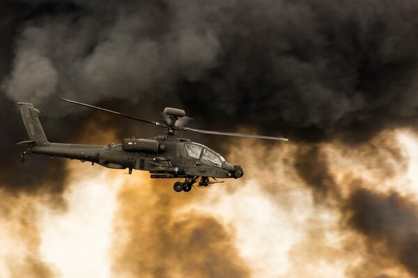 Apache helicopter gunship amid clouds of black smoke