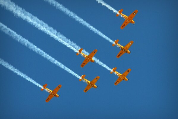 Ein Geschwader gelber Flugzeuge fliegt in den blauen Himmel