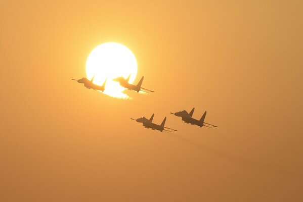 I caccia Su-27 volano sullo sfondo del sole