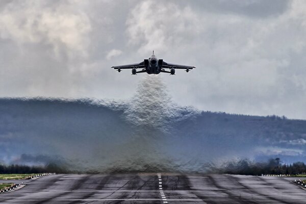 Fighter bomber takes off, heat blurs background