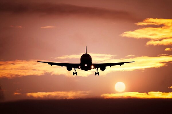 Avión en el fondo de una hermosa puesta de sol