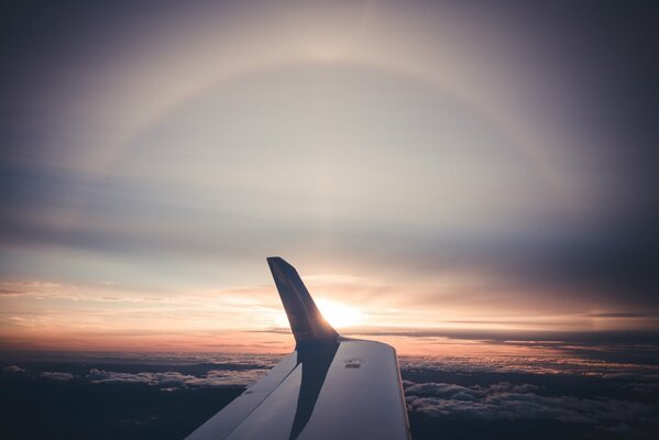 A wing from an airplane in a sunny sunset