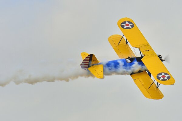 Avion biplan avec de la fumée vole à la parade