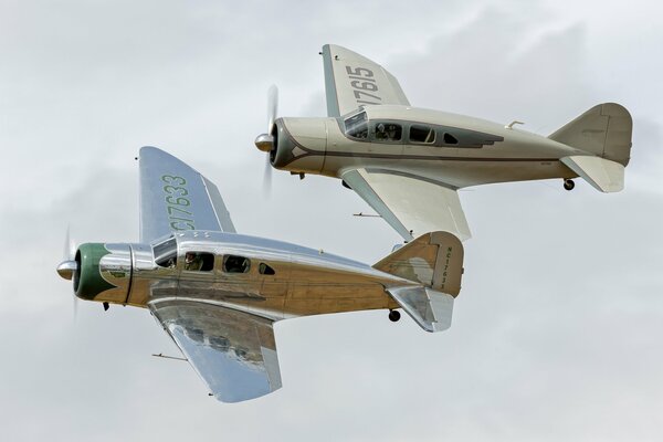 Dos aviones ligeros en vuelo en medio de nubes blancas y espesas