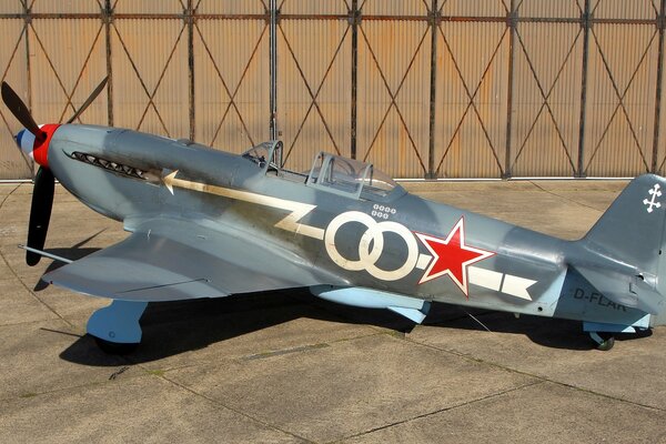 Un chasseur soviétique peint Yak-3 se trouve dans un hangar
